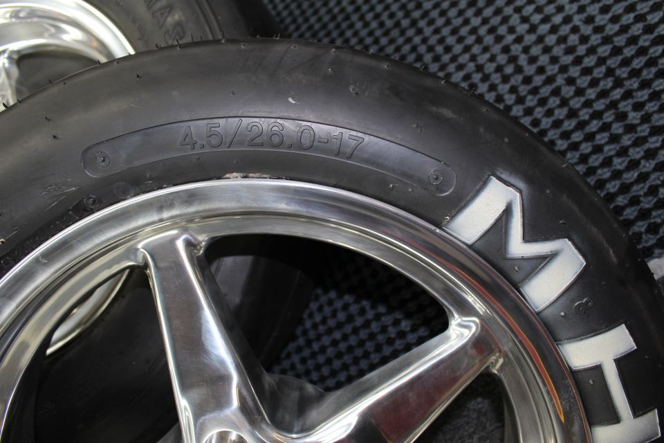 Close-up of tire sidewall stamped 4.5/26.0-17 beside a polished wheel and M&H lettering