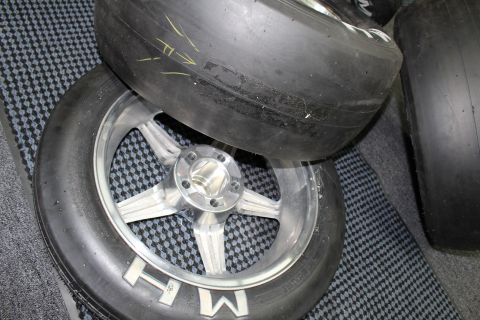 2003 Ford Crown Victoria - close-up of a polished five-spoke drag wheel with white MH lettering shows the center hub and slick tire.