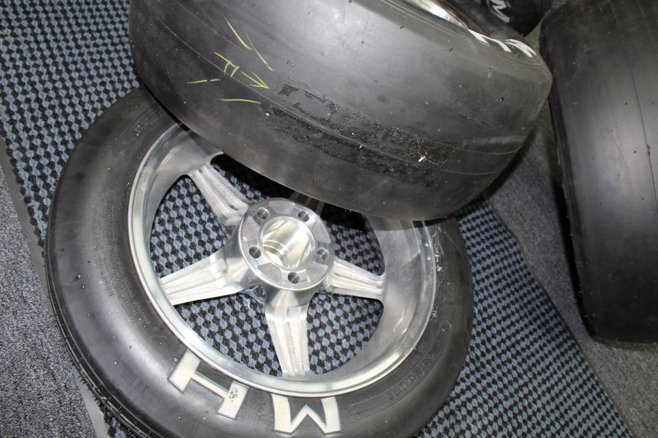 Close-up of polished five-spoke wheel with center hub and slick tire