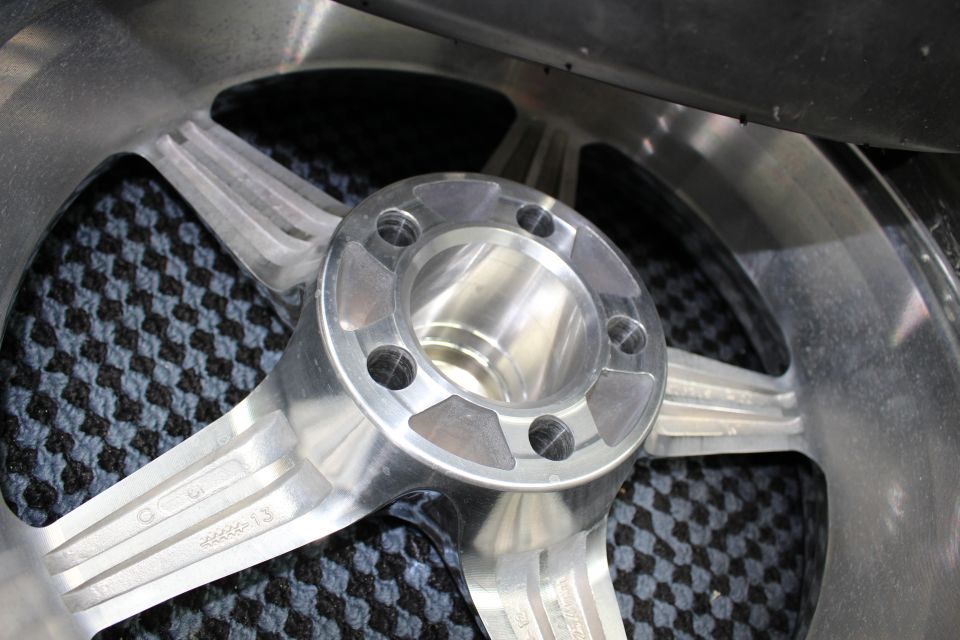 Close-up of polished wheel center hub and lug holes with carbon mat