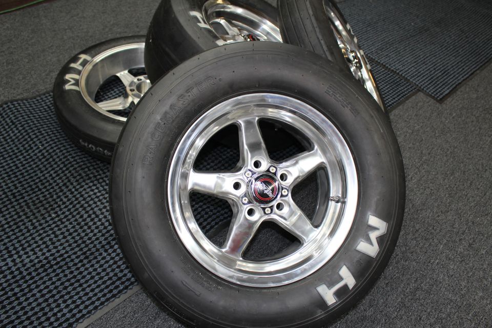 Polished five-spoke drag wheel on slick with red center cap