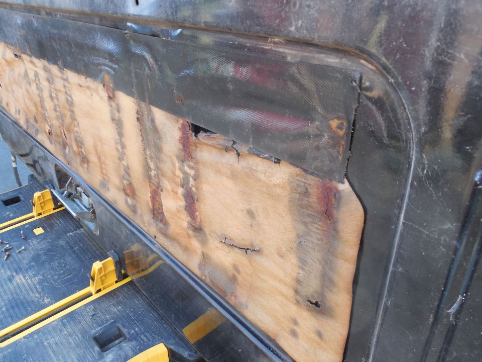 This is a factory water shedder.  It's taped along the bottom (the t/g is upside-down), and has a tacky adhesive along the top and across the middle.  But since the rain leaks in along the top where the weatherbelt meets the glass, and then drips off the bottom edge of the glass, it falls on the paper and then runs in between the paper the t/g.  The tape is supposed to create a seal & a dam that holds the rain in its pocket, forcing it to flow back into the t/g, but over the years, the rain works its way down past the tape.  Then it flows down between the t/g & the access panel, out onto the t/g threshold seal.  When that fills, it overflows the threshold and runs over to the carpet, where it seeps in and continues forward (assuming the truck is parked flat) under the rear seat, and down onto the front floor where it soaks into THAT carpet.  Eventually, it makes its way to the front door thresholds where it corrodes the wiring.