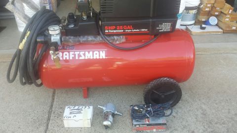 1989 Ford Bronco - A red Craftsman air compressor with a coiled hose and various accessories is displayed on a concrete surface.