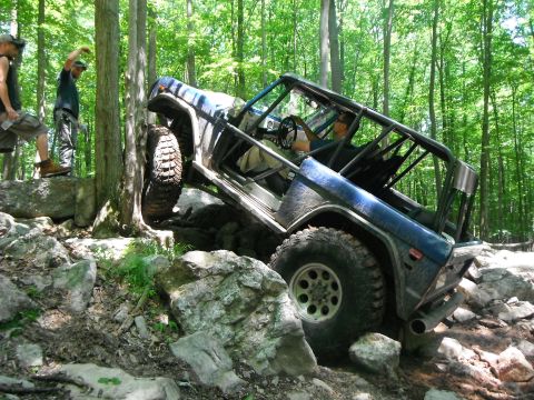 1988 Ford Bronco - This modified Ford Bronco is tackling a challenging rocky obstacle course in the woods.