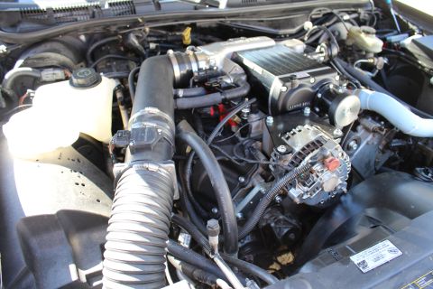 2003 Ford Crown Victoria - engine bay shows a Kenne Bell supercharger, chrome alternator and a corrugated intake hose.