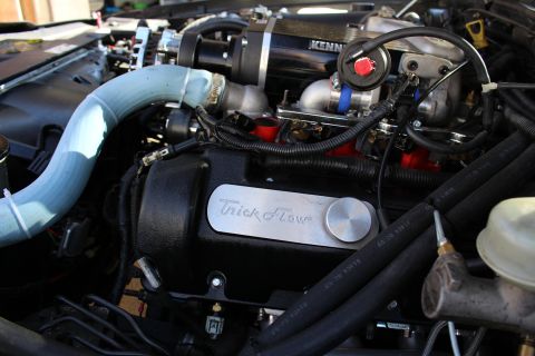 2003 Ford Crown Victoria - Three-quarter engine bay view of a Kenne Bell-supercharged motor with a Trick Flow valve cover, blue intake pipe and brake master cylinder…