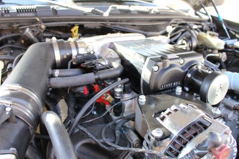 2003 Ford Crown Victoria - Detail of a Kenne Bell supercharger with its belt-driven drive snout and a chrome alternator mounted below in the engine bay.