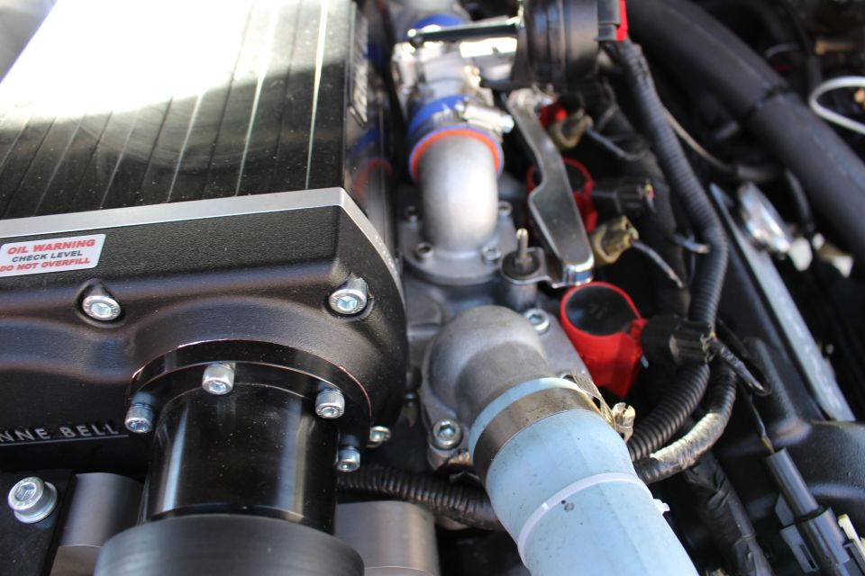 Kenne Bell supercharger with oil warning label, blue coolant hose and clamps