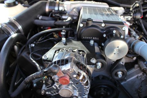 2003 Ford Crown Victoria - Close-up of a modified engine bay showing a black Kenne Bell supercharger above a polished chrome alternator and serpentine belt.