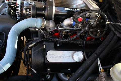 2003 Ford Crown Victoria - Engine bay detail of a Kenne Bell supercharger, throttle body and red fuel rails above a black Trick Flow valve cover.