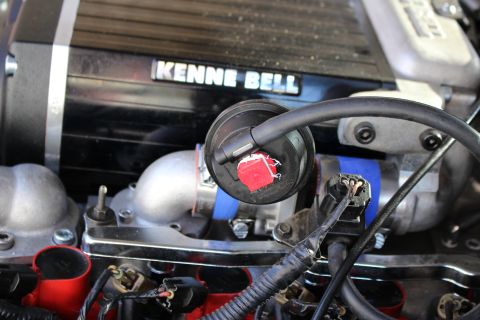 2003 Ford Crown Victoria - Engine close-up showing the Kenne Bell supercharger badge with a red oil-fill cap and blue-marked wiring beneath.