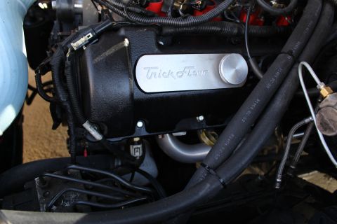 2003 Ford Crown Victoria - Engine bay close-up of a black Trick Flow valve cover with braided fluid lines and a light-blue silicone hose at left.