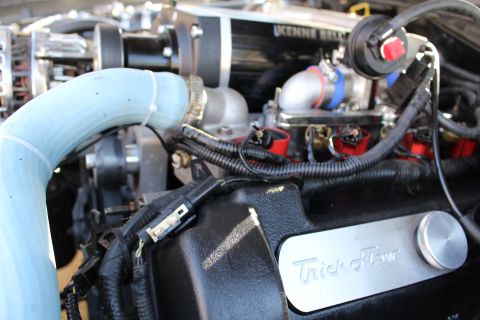 2003 Ford Crown Victoria - Engine bay detail of a Kenne Bell supercharger and red coils above a black Trick Flow valve cover with a blue silicone hose.