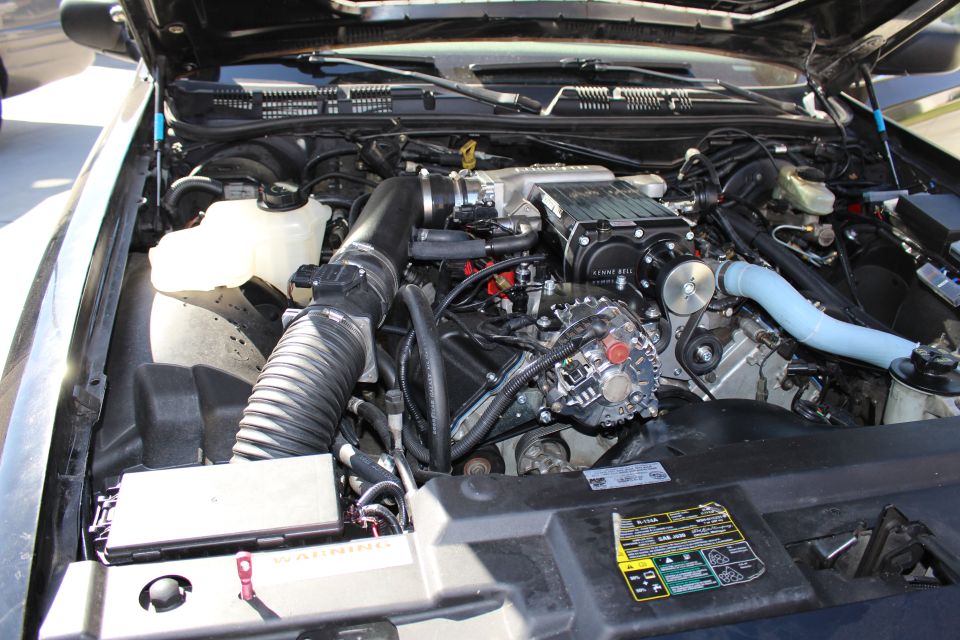 Engine bay with serpentine belt drive and supercharger