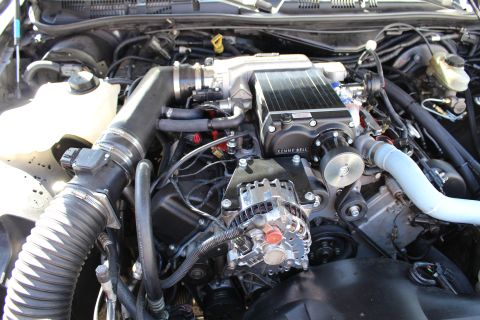 2003 Ford Crown Victoria - Close view of a Kenne Bell supercharger mounted on an engine, with chrome alternator and intercooler plumbing visible.