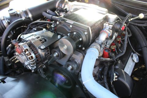2003 Ford Crown Victoria - Close view of a chrome alternator beside a Kenne Bell supercharger drive pulley, with a blue silicone hose and red plug wires.