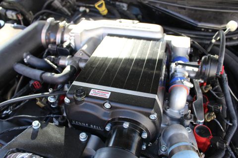 2003 Ford Crown Victoria - black Kenne Bell supercharger with finned top plate and red oil warning sticker installed on an engine, with red plug wires nearby.