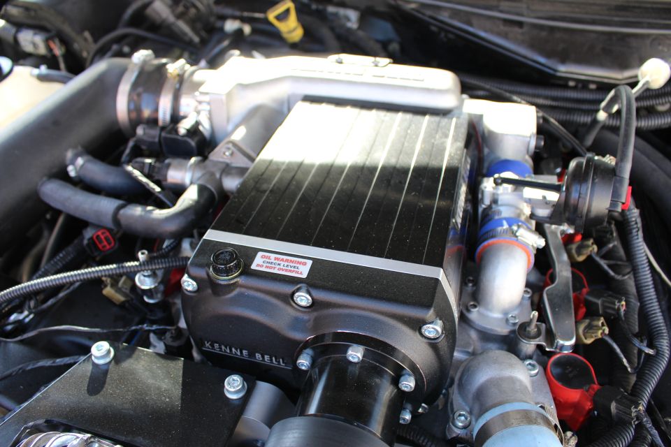 Black Kenne Bell supercharger with finned top and red oil warning sticker