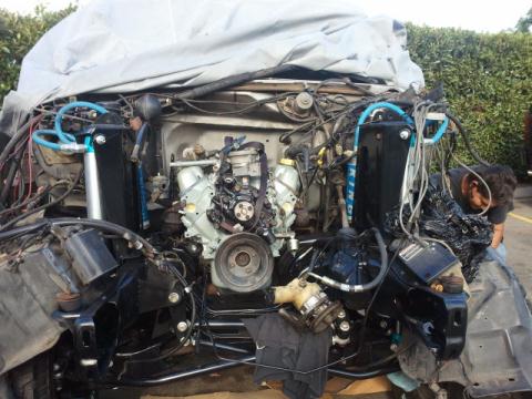 1986 Ford Bronco - Engine bay components and wiring are visible, with a tarp covering most of the vehicle.