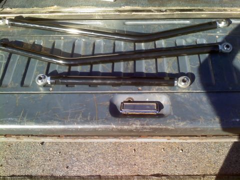 1986 Ford Bronco - Aftermarket suspension control arms are displayed on a vehicle's tailgate.