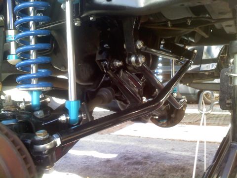 1986 Ford Bronco - Close-up of a vehicle's undercarriage, showing custom suspension parts.
