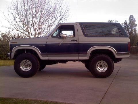 1986 Ford Bronco - This lifted Ford Bronco features a two-tone paint scheme and large off-road tires.