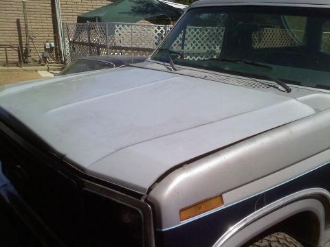 1986 Ford Bronco - Close-up of a truck's hood and fender, showing a two-tone paint scheme and a watermark.