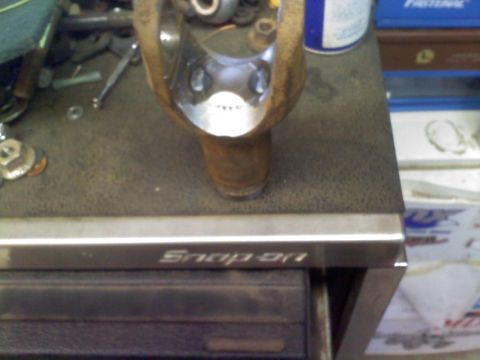 1986 Ford Bronco - A close-up shows a rusty universal joint part resting on a workbench, with a Snap-on logo visible below.