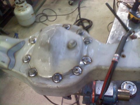 1986 Ford Bronco - A differential housing is shown on a workbench, undergoing modifications with welding.