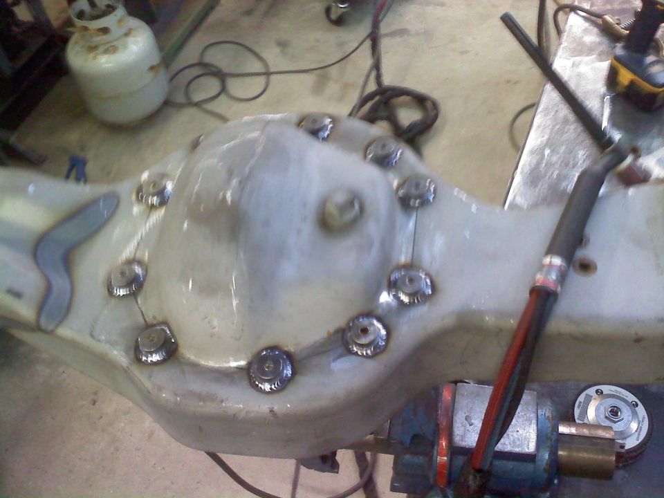 Differential housing with welded bolts, on a workbench with welding equipment
