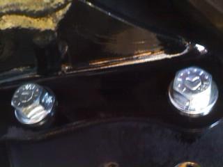 1986 Ford Bronco - Close-up of hardware on a black component, with Supermotors.net branding.