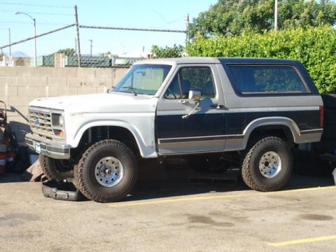 1986 Ford Bronco - This two-tone Ford Bronco, likely from the early 1980s, is parked on a paved surface.