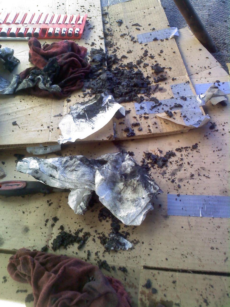 Dirty rags and grease splatters on cardboard with a socket set