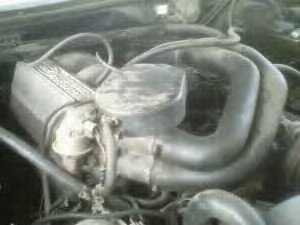 1986 Ford Bronco - Close-up view of the engine compartment, showing various hoses and the air intake system.