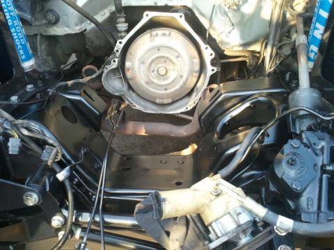 1986 Ford Bronco - Close-up view of engine and transmission components, with visible steering parts and shock absorbers.