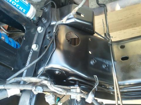 1986 Ford Bronco - Close-up view of suspension components, including a blue shock absorber and black metal framing.