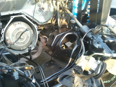 1986 Ford Bronco - The engine bay shows various mechanical parts, including the transmission housing and exhaust system.