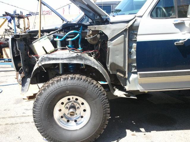 1986 Ford Bronco front end disassembled, showing engine bay components and fender removed