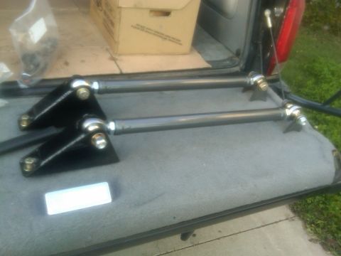 1986 Ford Bronco - Aftermarket suspension components are laid out in the cargo area of a vehicle, ready for installation.