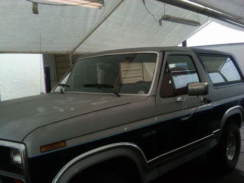 1986 Ford Bronco - The side of a 1986 Ford Bronco shows its two-tone paint scheme and chrome trim.