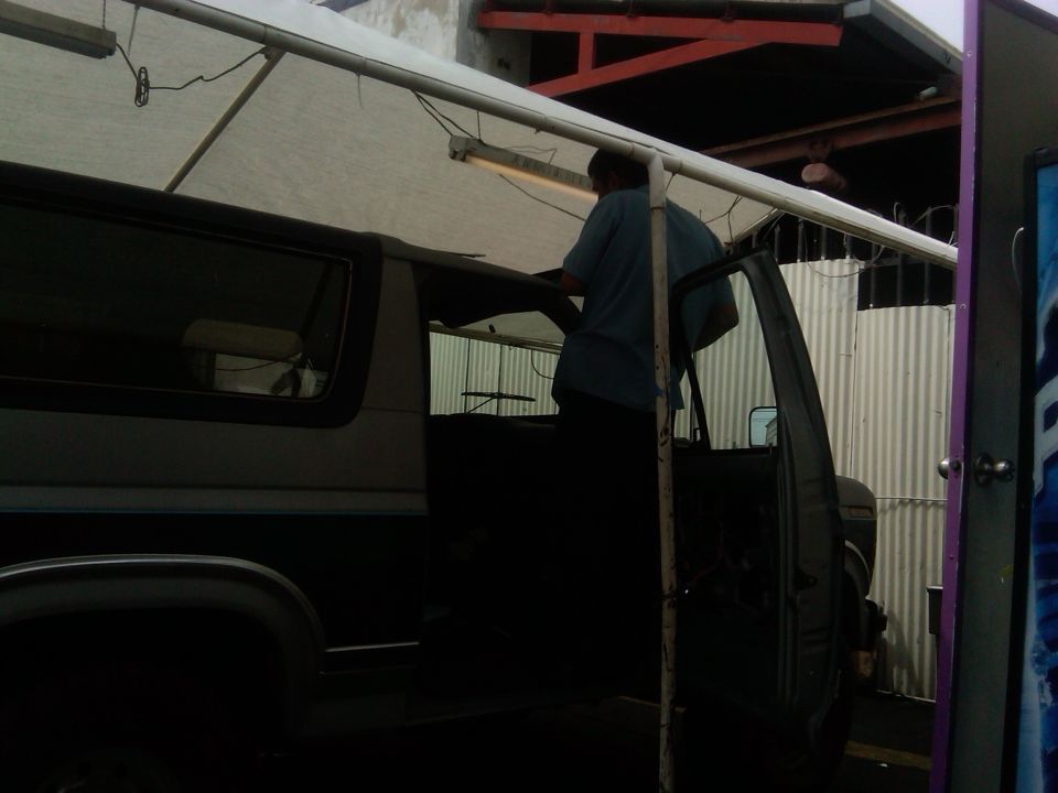 1986 Ford Bronco with open driver's door, person working inside