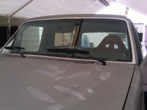 1986 Ford Bronco - The interior of a truck is visible, a red racing seat and a partial view of the dashboard and windshield wipers.
