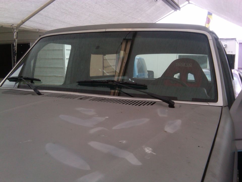 Interior view of a truck with a red racing seat visible through the windshield