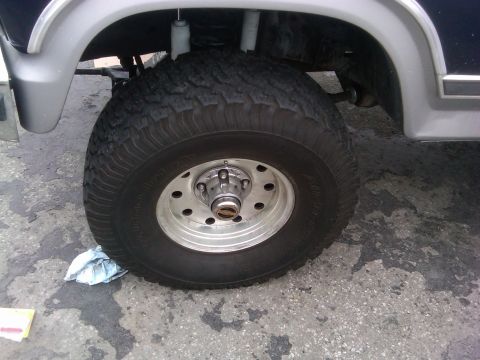 1986 Ford Bronco - Close-up of a vehicle's wheel and fender assembly, showing tire and rim details.