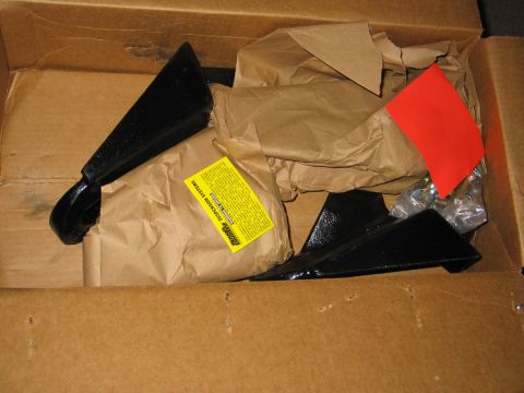 1995 Ford Bronco - A box contains black metal lift kit parts, wrapped in brown paper, with an instruction label visible.