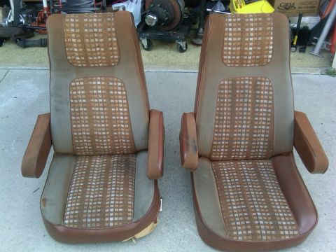 1986 Ford Bronco - Pair of vintage bucket seats, likely from a truck or SUV, displayed outdoors.