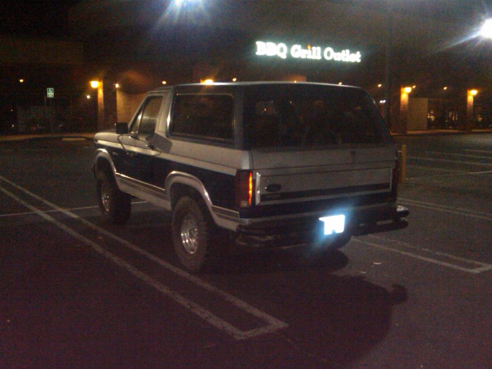 Two-tone dark blue and silver Ford Bronco parked at night