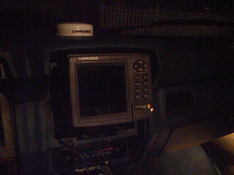 1986 Ford Bronco - The interior of a vehicle shows a dashboard with a Lowrance GPS unit and a separate radar dome on top.