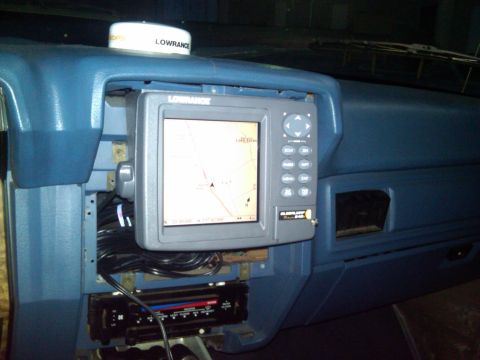 1986 Ford Bronco - The dashboard of a vehicle features a Lowrance GPS unit mounted above the radio, with visible wiring.