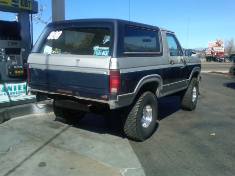 1986 Ford Bronco - This 1986 Ford Bronco is seen from the rear at a gas station, a two-tone paint scheme and off-road tires.